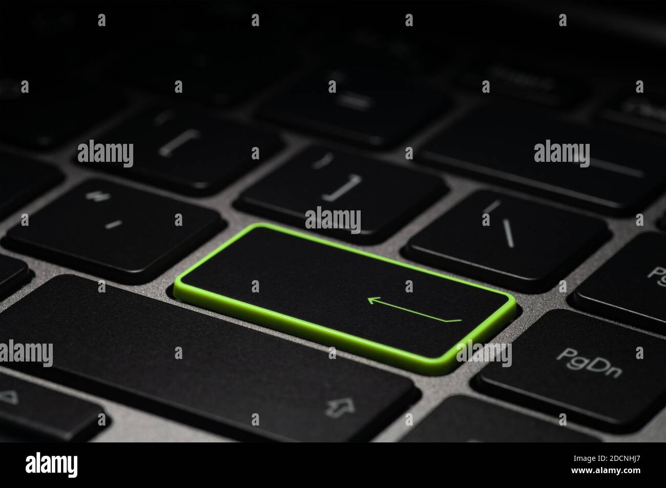 Tasto verde invio sulla tastiera del computer portatile al buio. Messa a  fuoco selettiva Foto stock - Alamy