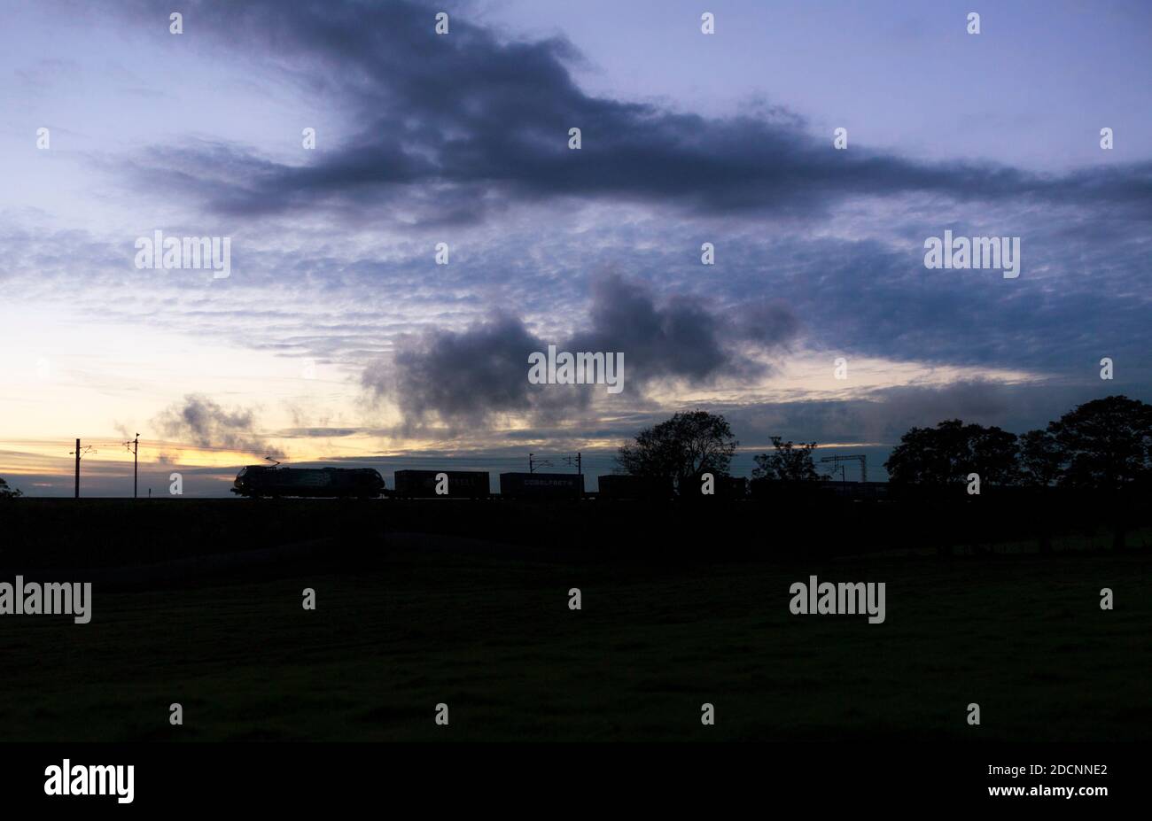 Direct rail Services class 88 motrice sulla linea principale della costa occidentale al tramonto con la Stobart / Tesco meno co2 contenitore intermodale treno merci Foto Stock