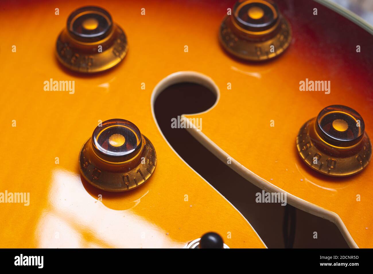 pulsanti elettronici vintage rotondi su una chitarra elettrica scottata Foto Stock