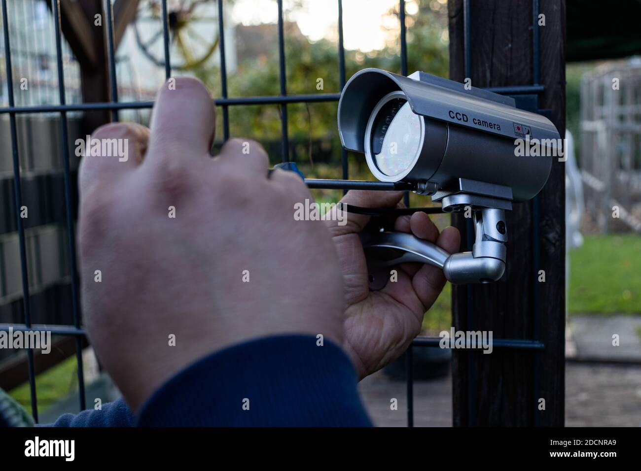 Professionista che ripara e installa la telecamera di sorveglianza. Foto Stock