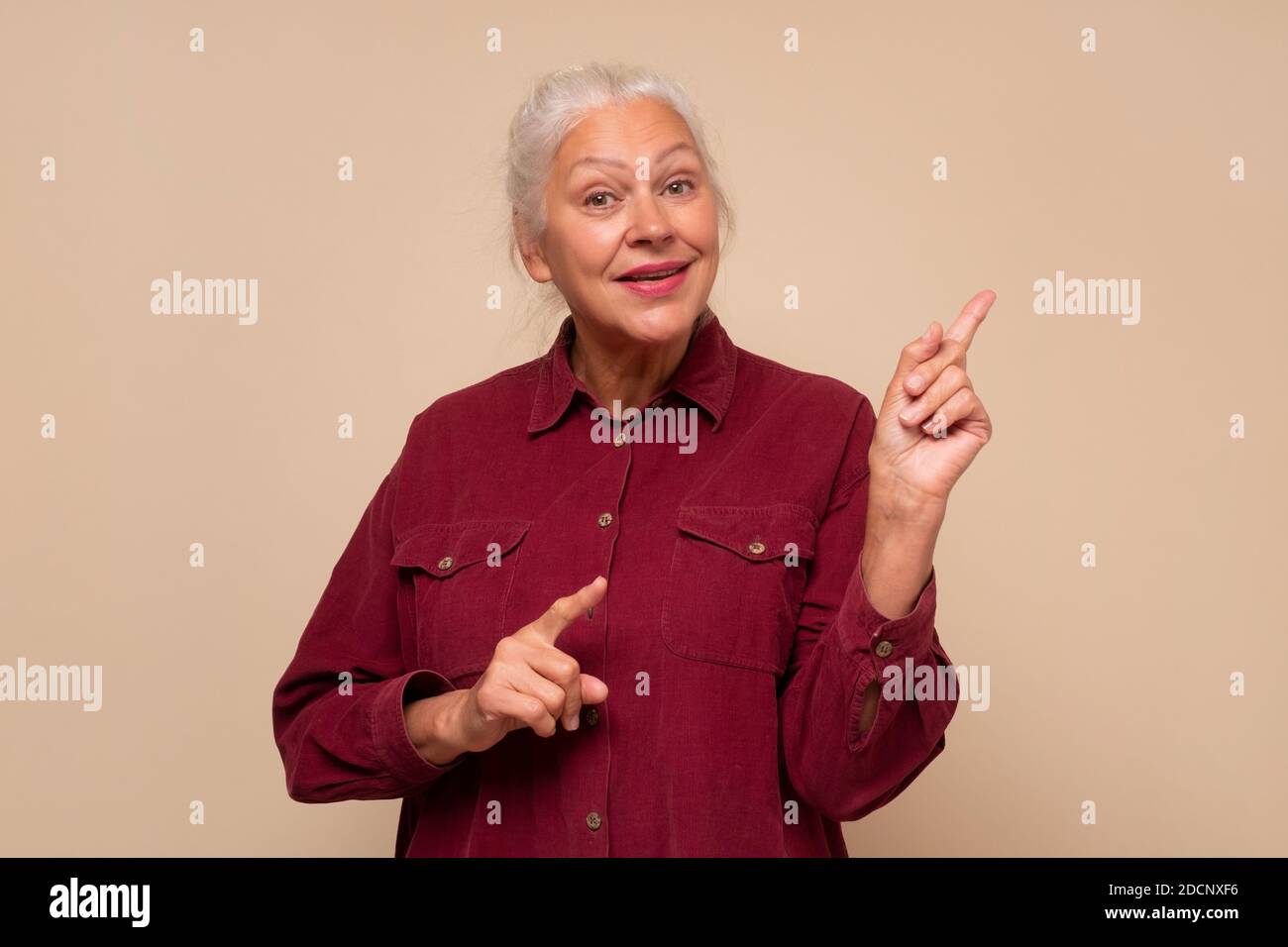 Stupito vecchia donna che indica lo spazio di copia da parte Foto Stock