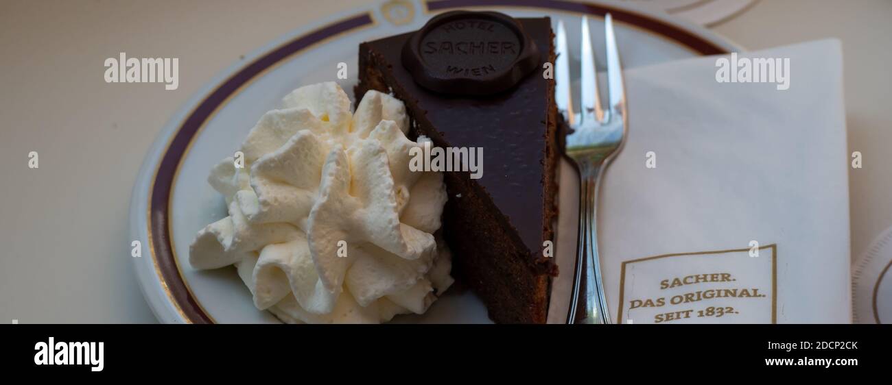 VIENNA, AUSTRIA - 14 LUGLIO 2019: Vista panoramica della fetta di torta Sacher-Torte sul piatto al Cafe Sacher con tovagliolo di marca Foto Stock