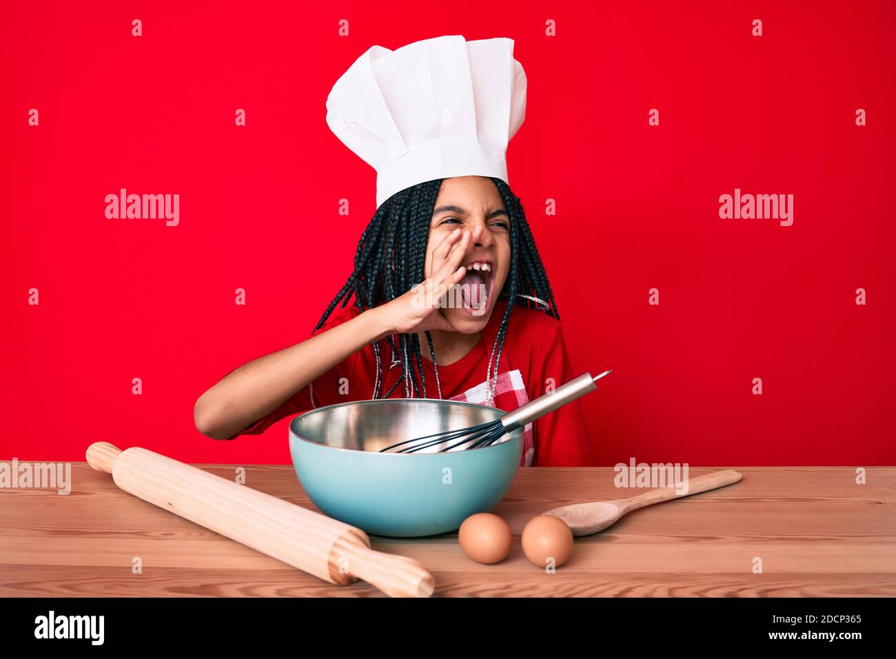 Giovane ragazza afroamericana bambino con trecce indossando grembiule