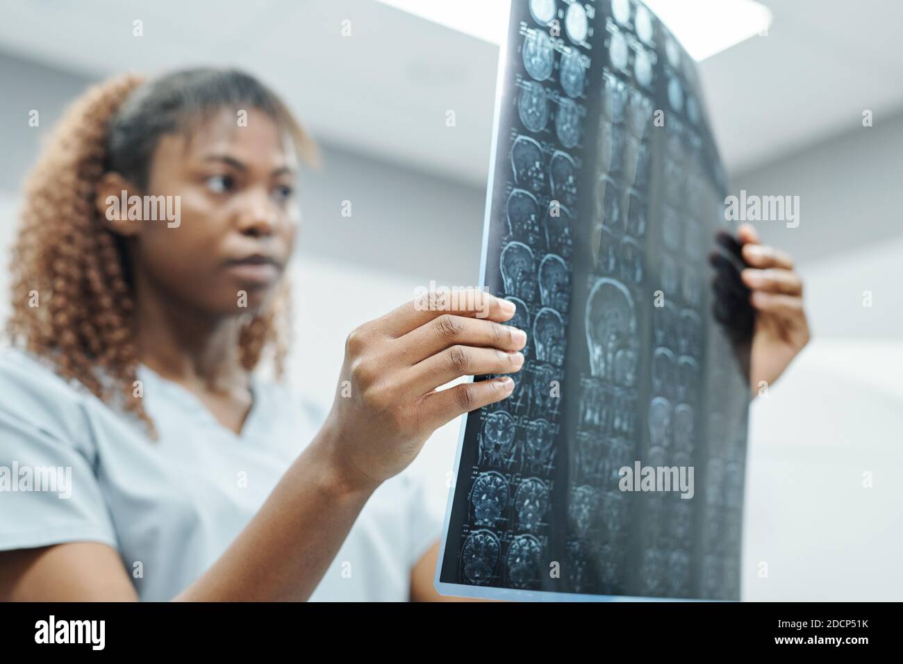 Mano della giovane radiologa africana in uniforme analisi radiologica immagine Foto Stock
