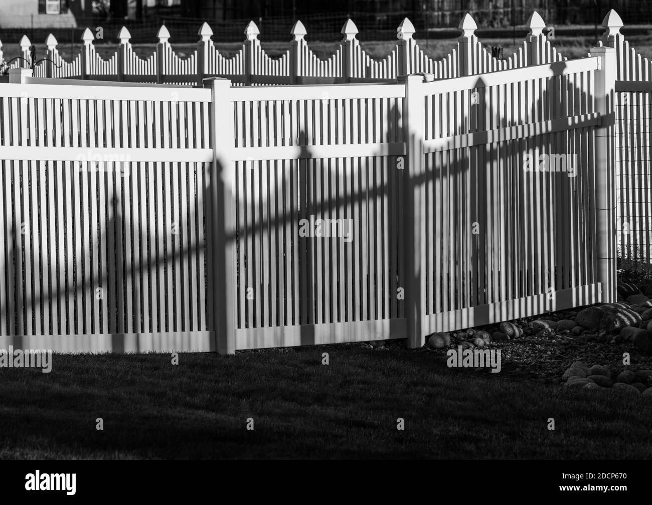 Vista in bianco e nero di recinzione e ombre in stile picket in vinile bianco; Salida; Colorado; USA Foto Stock