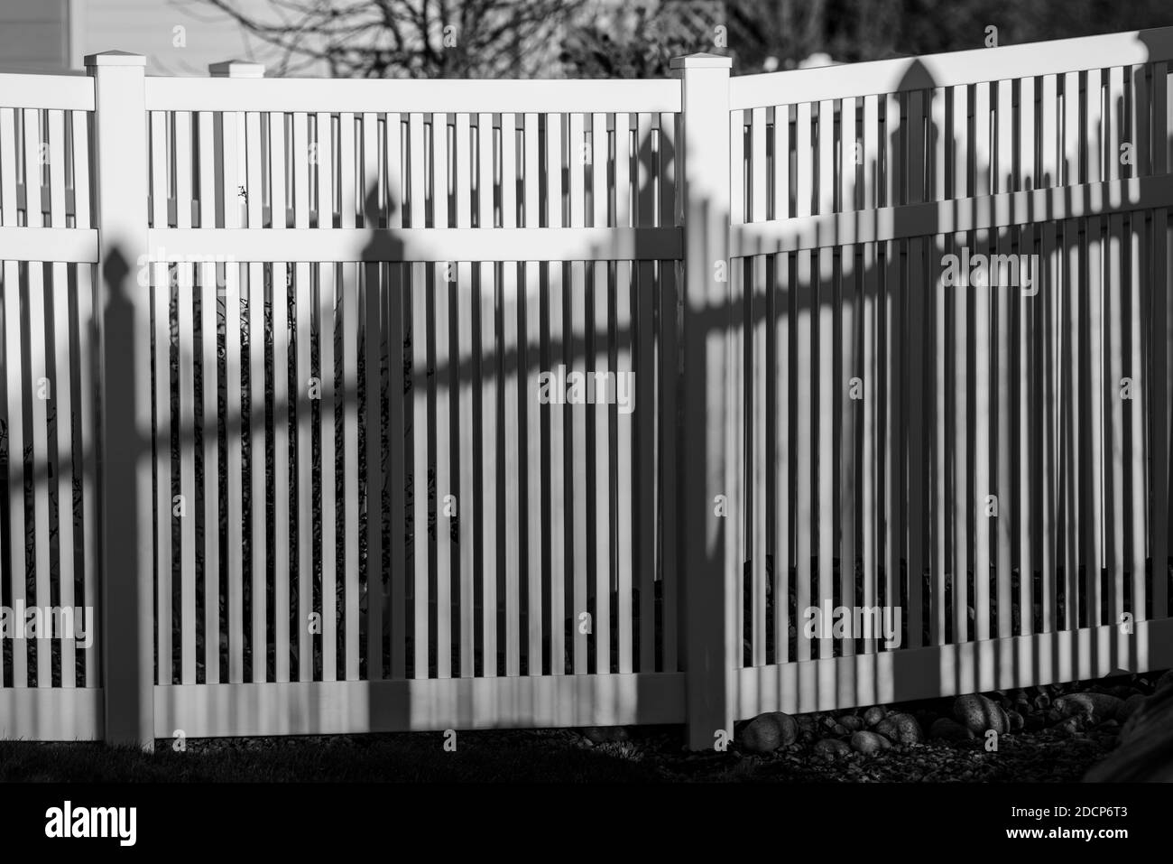 Vista in bianco e nero di recinzione e ombre in stile picket in vinile bianco; Salida; Colorado; USA Foto Stock