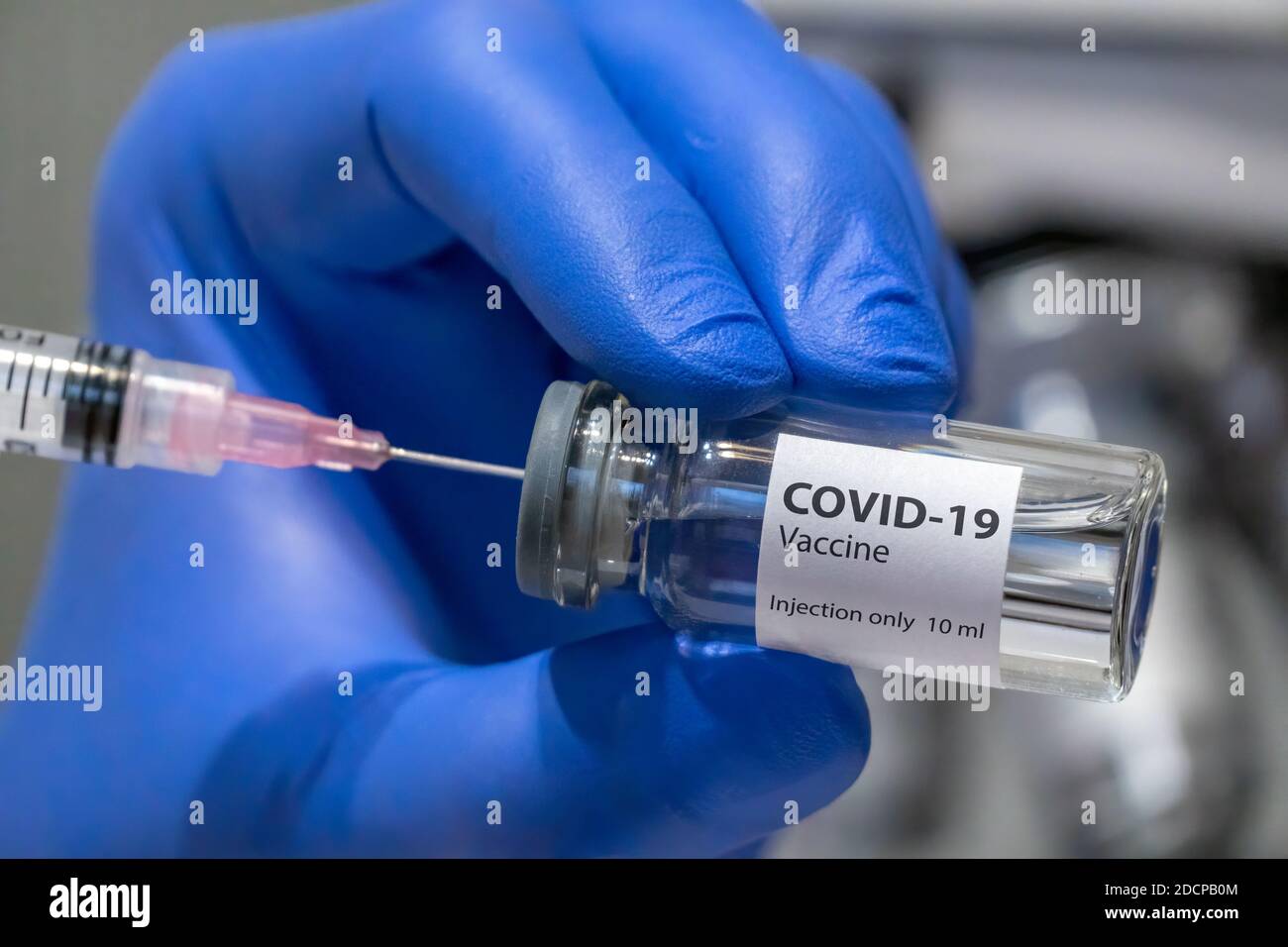 Il medico o lo scienziato sta tenendo in mano il vaccino COVID-19. Foto Stock