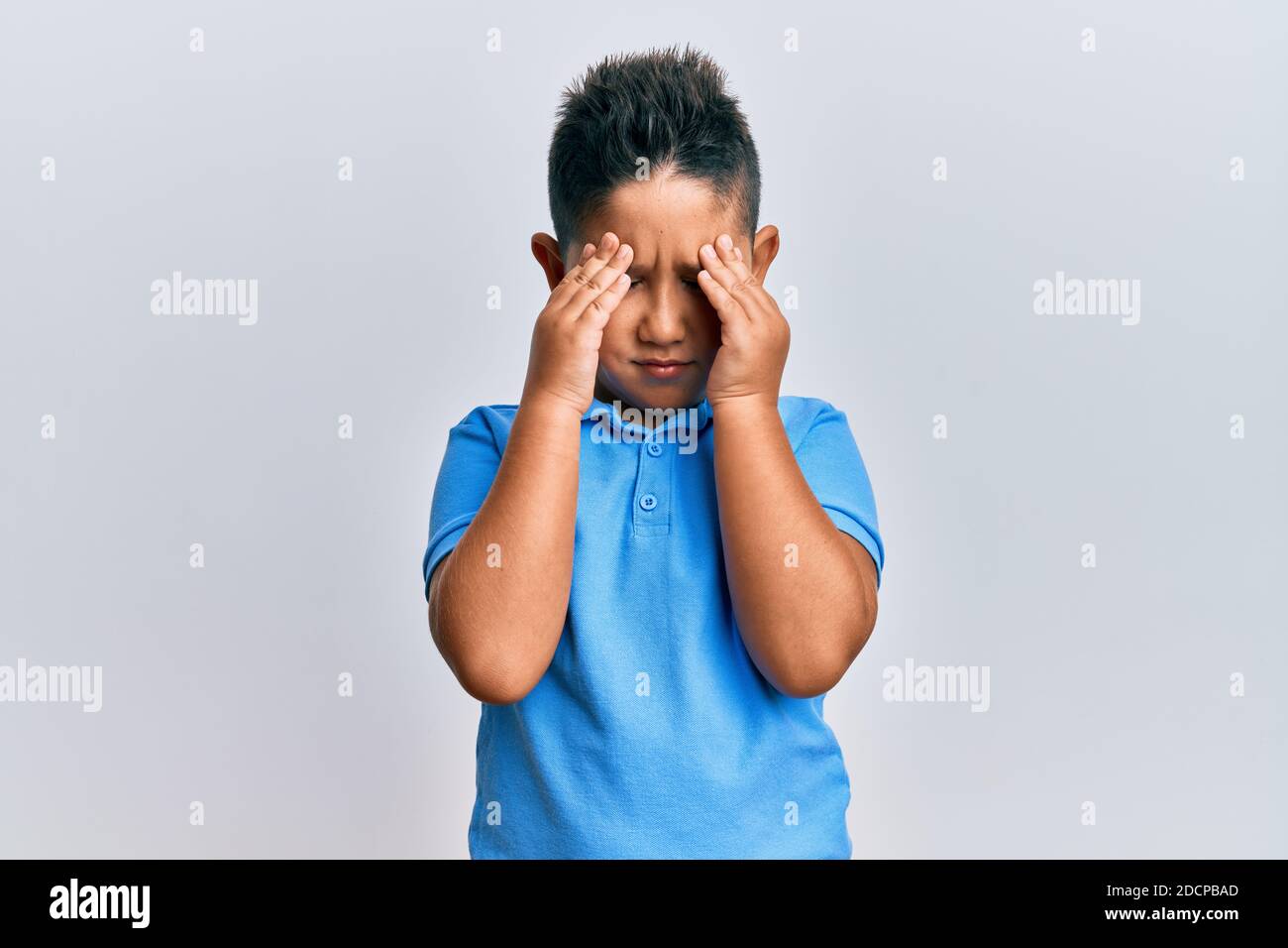 Bambino ispanico bambino che indossa abiti casual che soffrono di mal di  testa disperato e stressato perché dolore ed emicrania. Mani sulla testa  Foto stock - Alamy