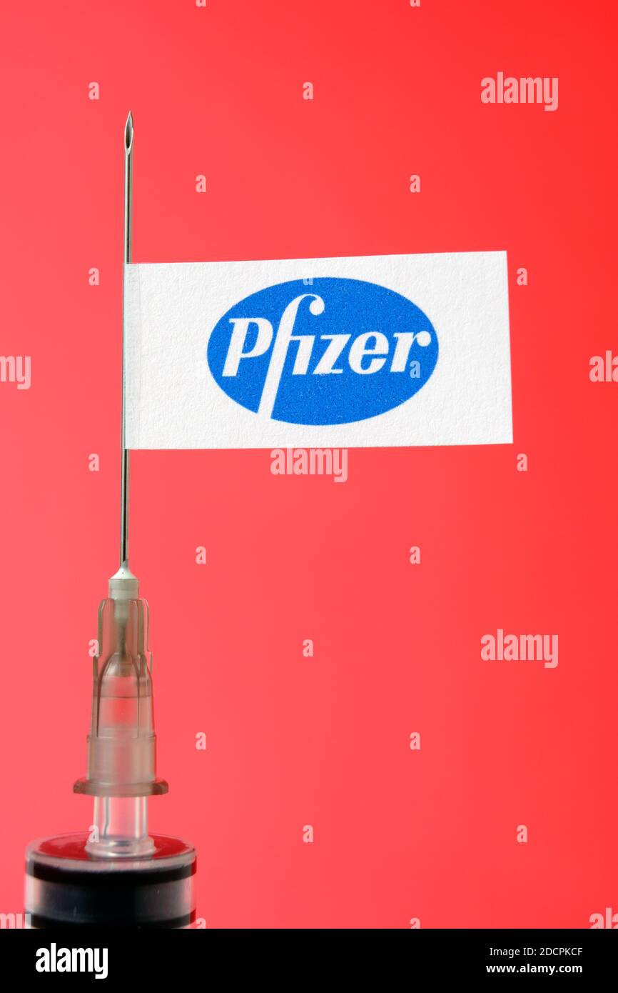 Stafford / Regno Unito - Novembre 22 2020: Pfizer Vaccine Covid-19 Concept. Ago della siringa e adesivo Pfizer su di esso, sfondo sfocato. Foto reale Foto Stock