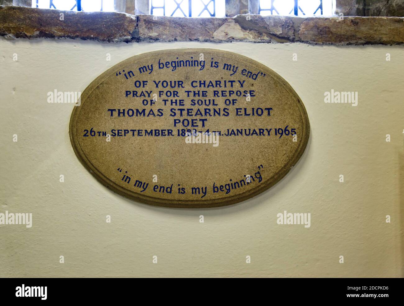 Finestre in vetro piombato sopra una targa commemorativa inscritta per il poeta TS Eliot all'interno della chiesa di St. Michael e All Angeles a East Coker, Somerset, Inghilterra Foto Stock