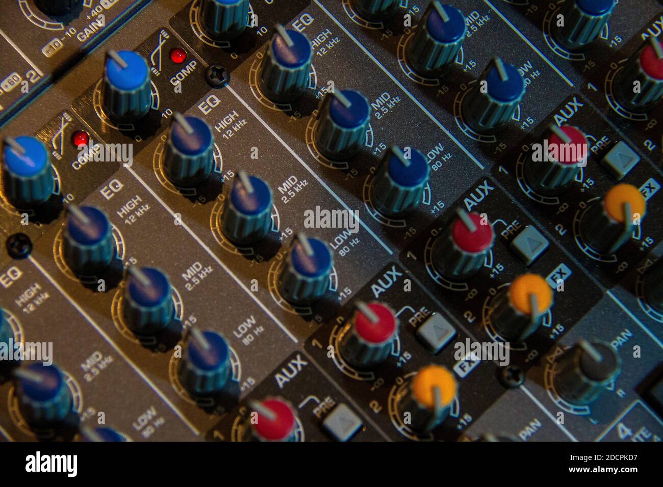 Regolazione ad alto angolo dei controlli EQ su un mixer audio. Foto Stock