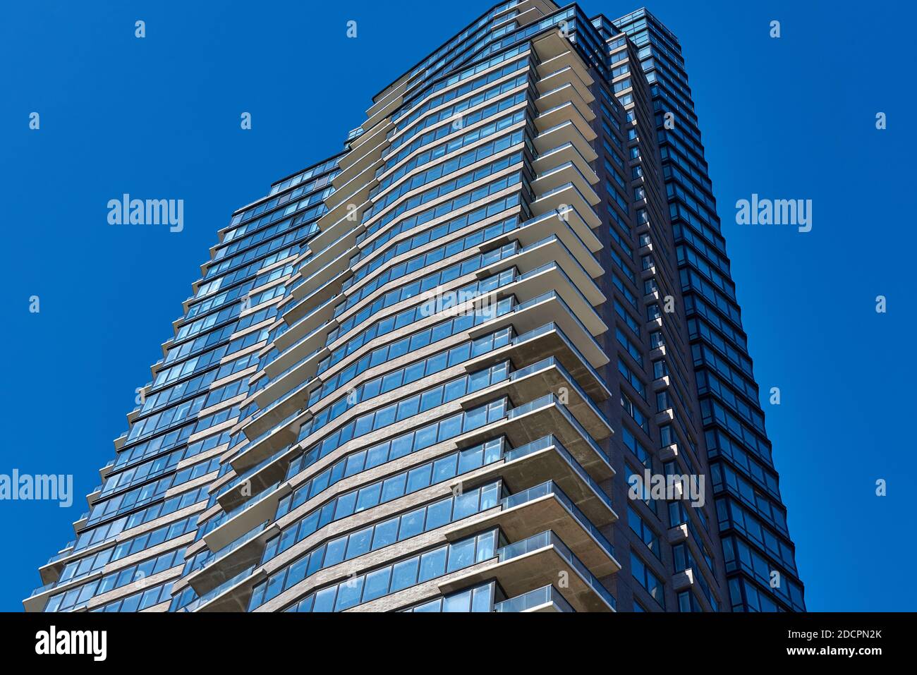 Brooklyn, NY - Novembre 14 2020: La cima di un nuovo grattacielo residenziale a Greenpoint, New York, scolpito contro un cielo blu senza nuvole. L'edificio è Foto Stock