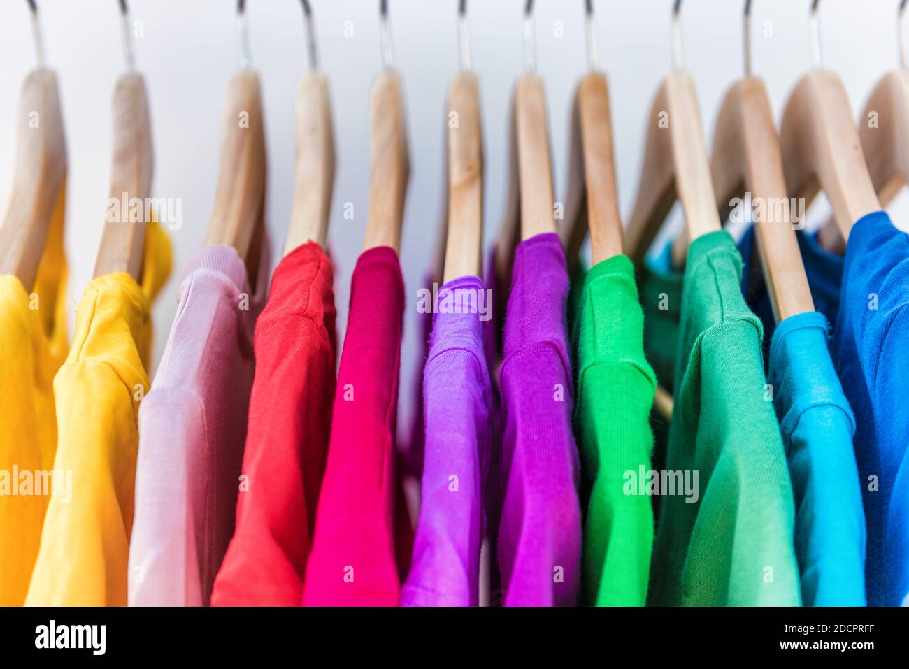 Moda Abbigliamento su rack - luminoso colorato armadio. Primo piano della rainbow scelta colori alla moda di usura femmina su appendiabiti in store in un armadio o in primavera Foto Stock