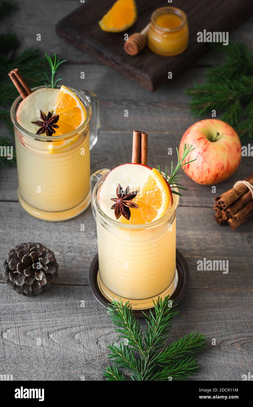 Bevande calde al rum, al whisky o al brandy di mele su un rustico tavolo di legno. Stagionale inverno o Natale bevanda piccante caldo, sidro mulled. Foto Stock