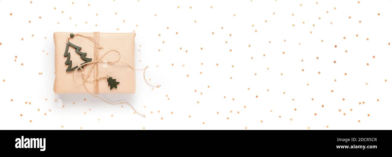 Confezione regalo avvolta in carta artigianale con decorazioni su sfondo bianco, banner lungo con confetti kraft Foto Stock