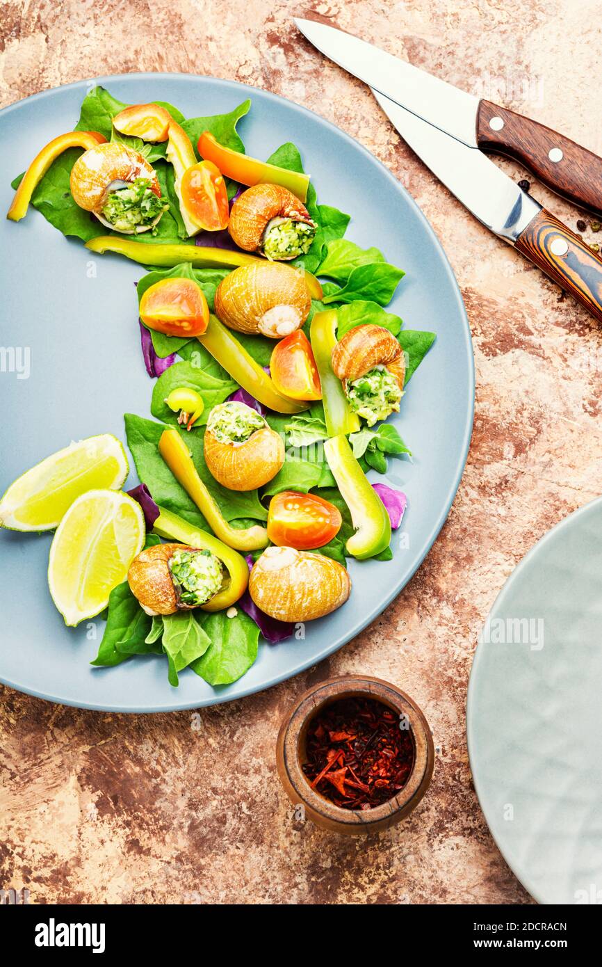 Insalata con lumache, spinaci, pomodoro e pepe. Insalata di verdure salutari Foto Stock