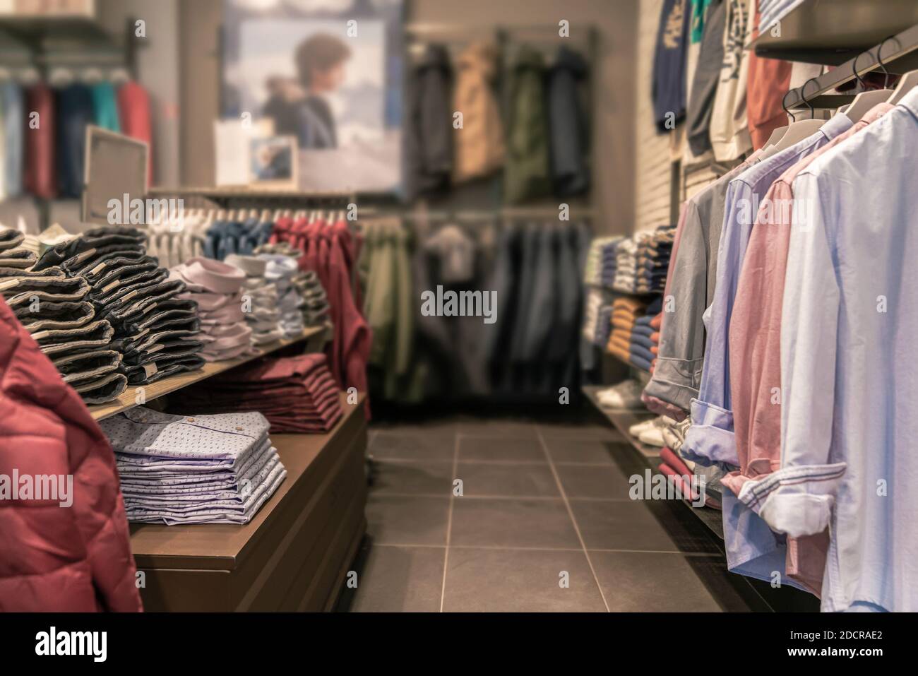 sfondo sfocato - negozio di abbigliamento uomo. appendiabiti per camicie,  giacche, pantaloni, shopping alla moda Foto stock - Alamy