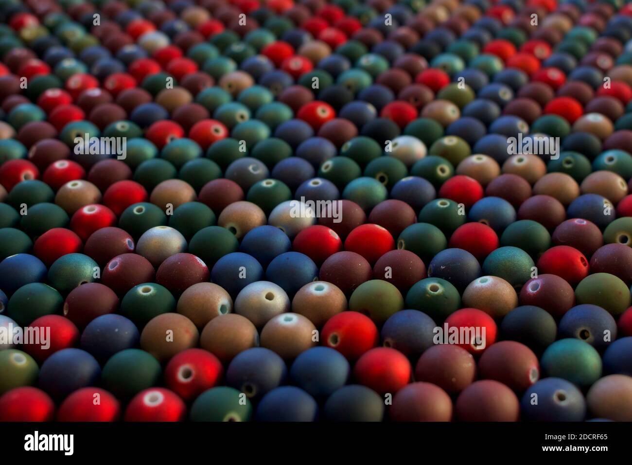 Set di perle opache e di molti colori che assomiglia a mini palle di Natale. Perle di semi da utilizzare in collane e bracciali. Foto Stock