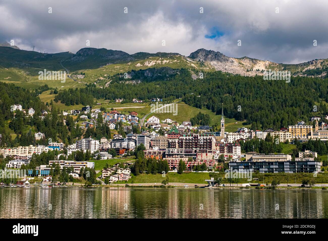 La città di St. Moritz si trova sulle rive del lago di St. Moritz, alle pendici meridionali delle Alpi dell'Albula in lontananza. Foto Stock