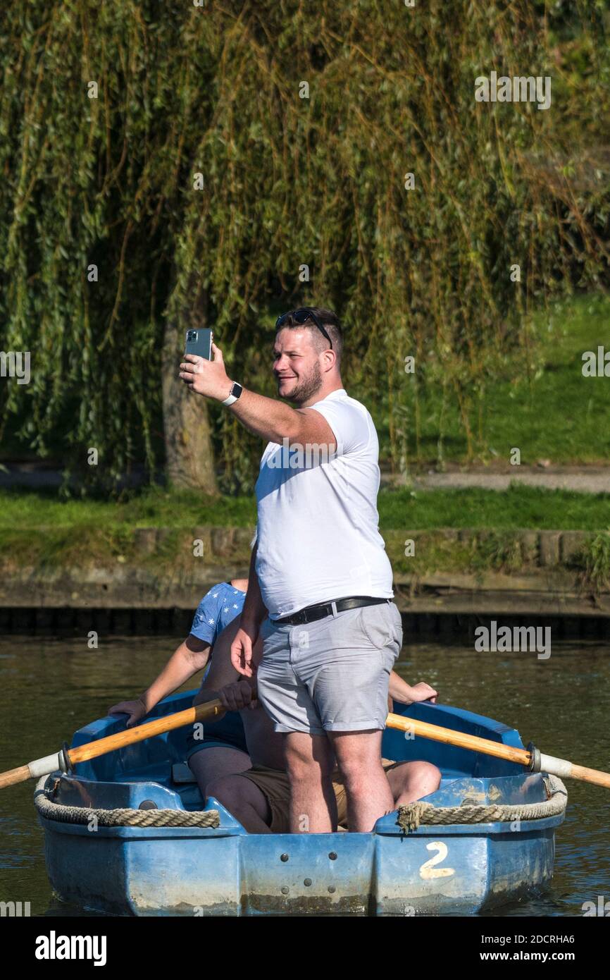Un turista che si alza in piedi su in un gommone e usa uno smartphone per scattare una foto selfie a Newquay in Cornovaglia. Foto Stock