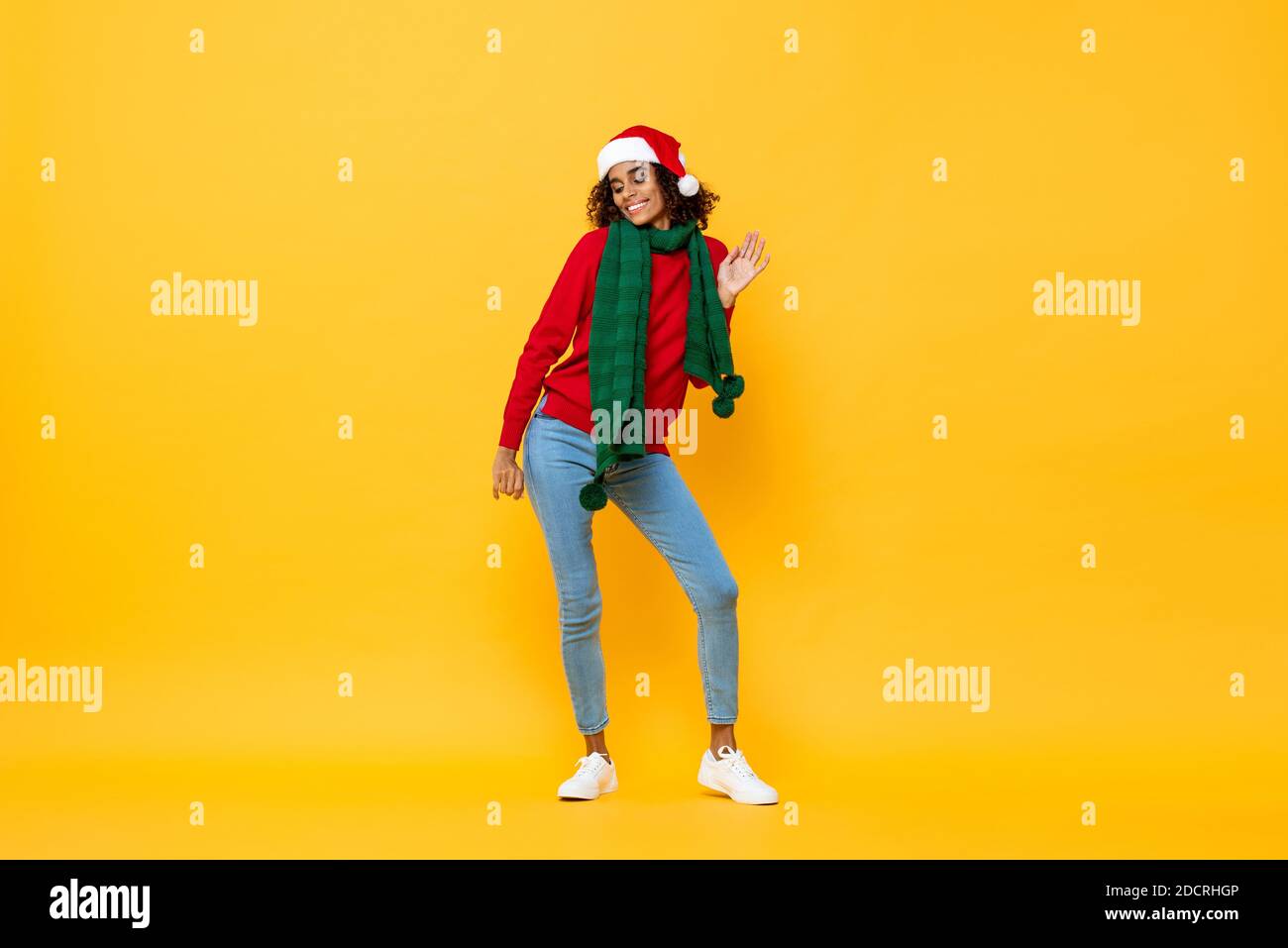 Ritratto a lunghezza intera di gioiosa donna felice in abbigliamento di Natale ballare su isolati sfondo giallo studio Foto Stock