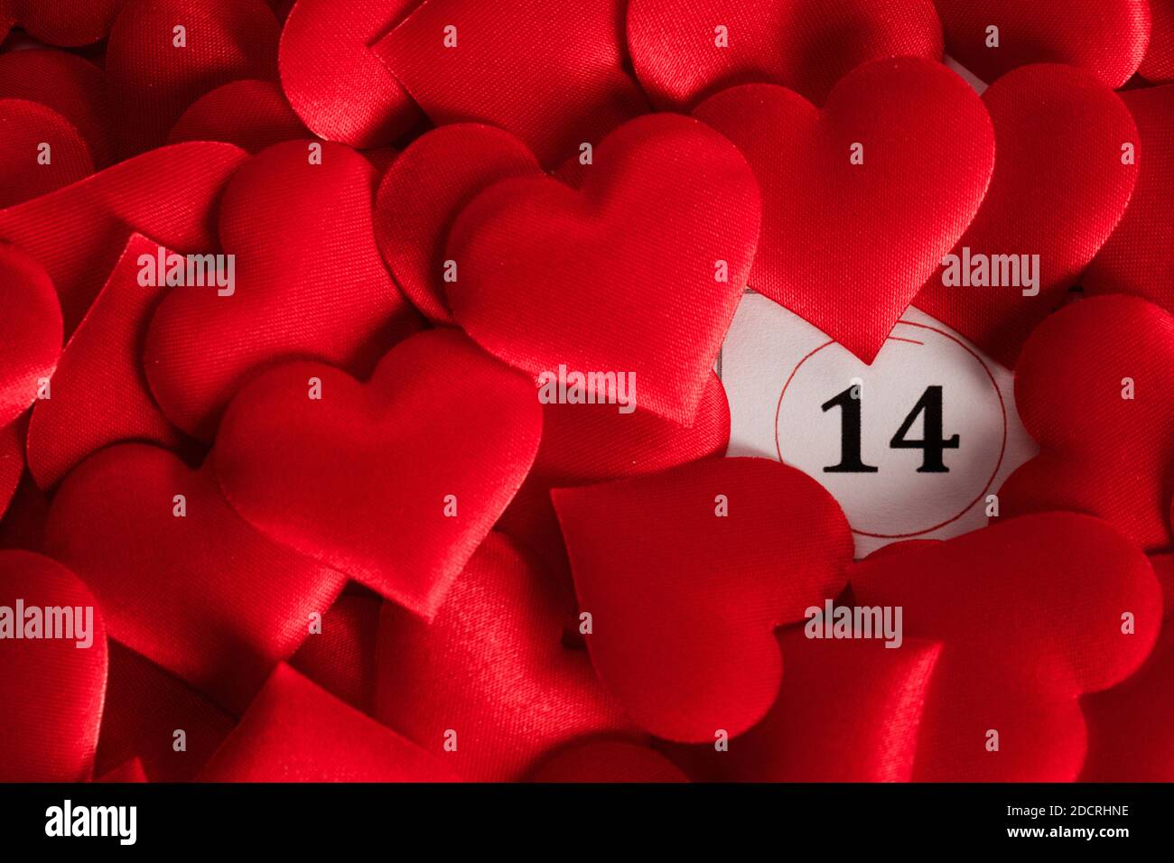Il giorno di San Valentino Rossi cuori di seta sul calendario con 14 febbraio data sfondo, amore, celebrazione concept Foto Stock