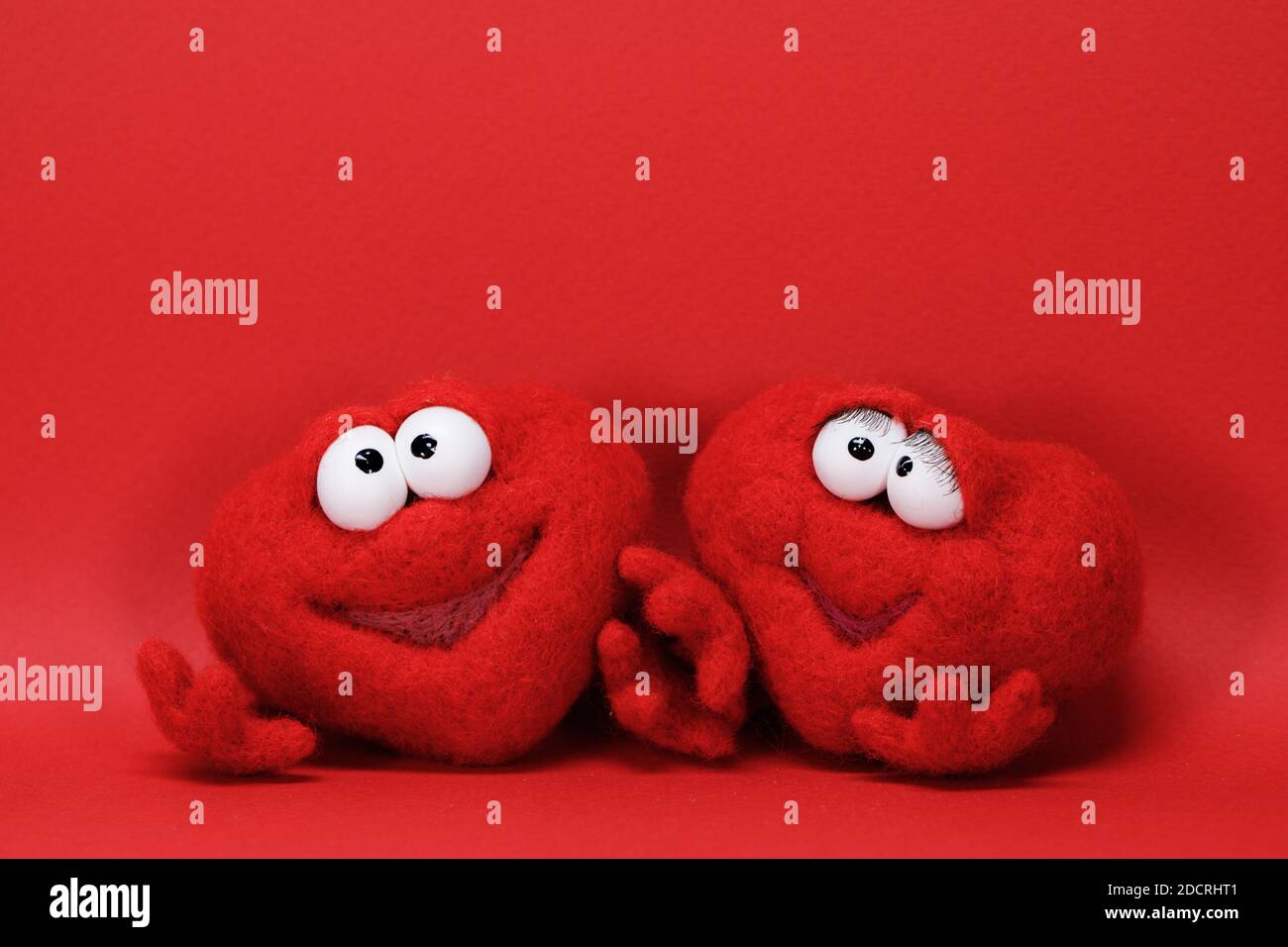 Due cuori rossi giocattolo su sfondo rosso con spazio di copia per il testo, simbolo dell'amore, healtcare, concetto di giorno di valentines Foto Stock