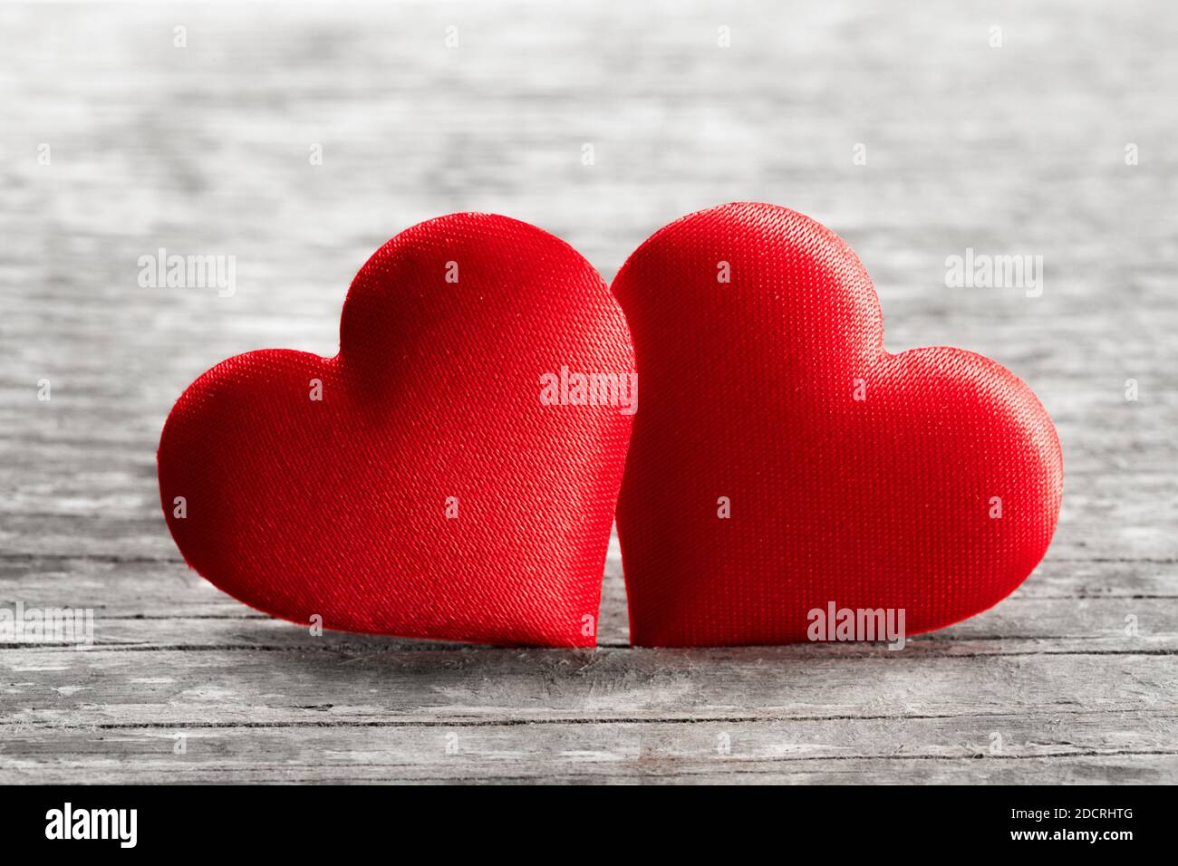 Il giorno di San Valentino Rossi due cuori di seta su sfondo di legno, il concetto di amore Foto Stock