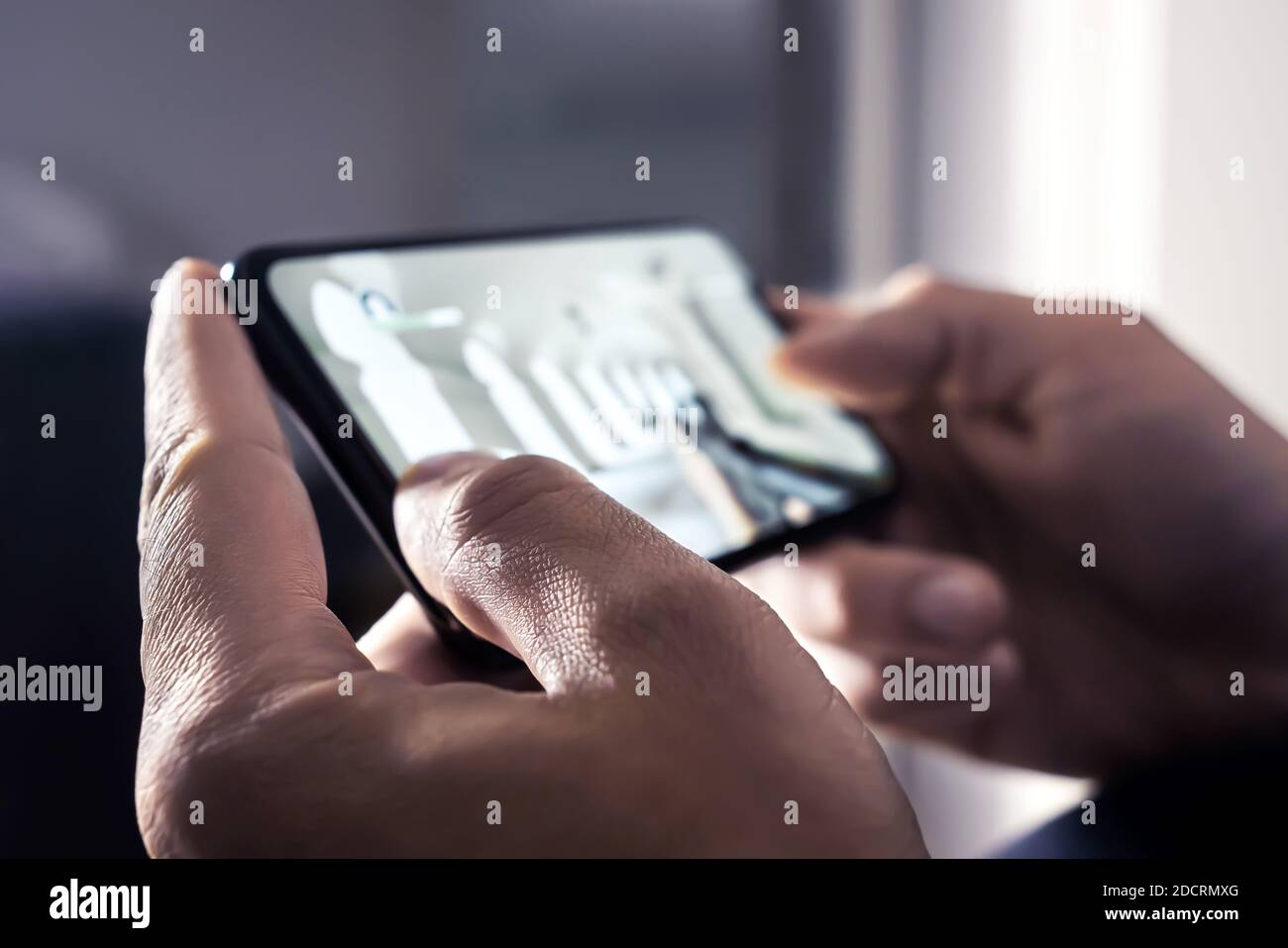 Giochi per dispositivi mobili sul telefono o video in streaming dal vivo su giochi o eSport in fps. Giocatore che gioca online con uno sparatutto in prima persona con smartphone. Foto Stock