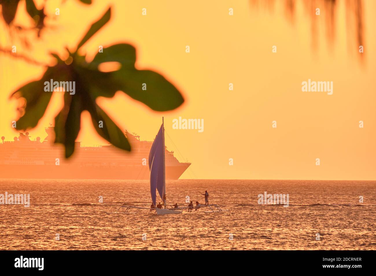 Tramonto sull'isola di Boracay. Vela e altre barche tradizionali con turisti in mare sullo sfondo del sole tramontare. Celebrità Millennio Foto Stock