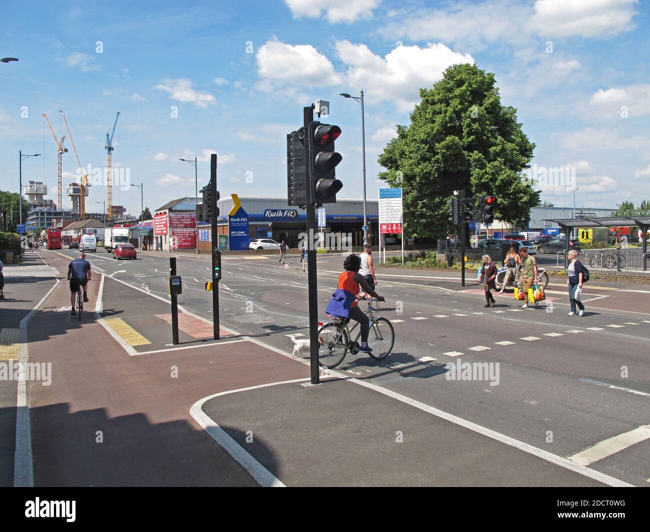 I ciclisti e i pedoni utilizzano un nuovo passaggio separato su Lea Bridge Road, Londra, Regno Unito. Parte del programma Mini Holland di Waltham Forest per la bicicletta più sicura Foto Stock