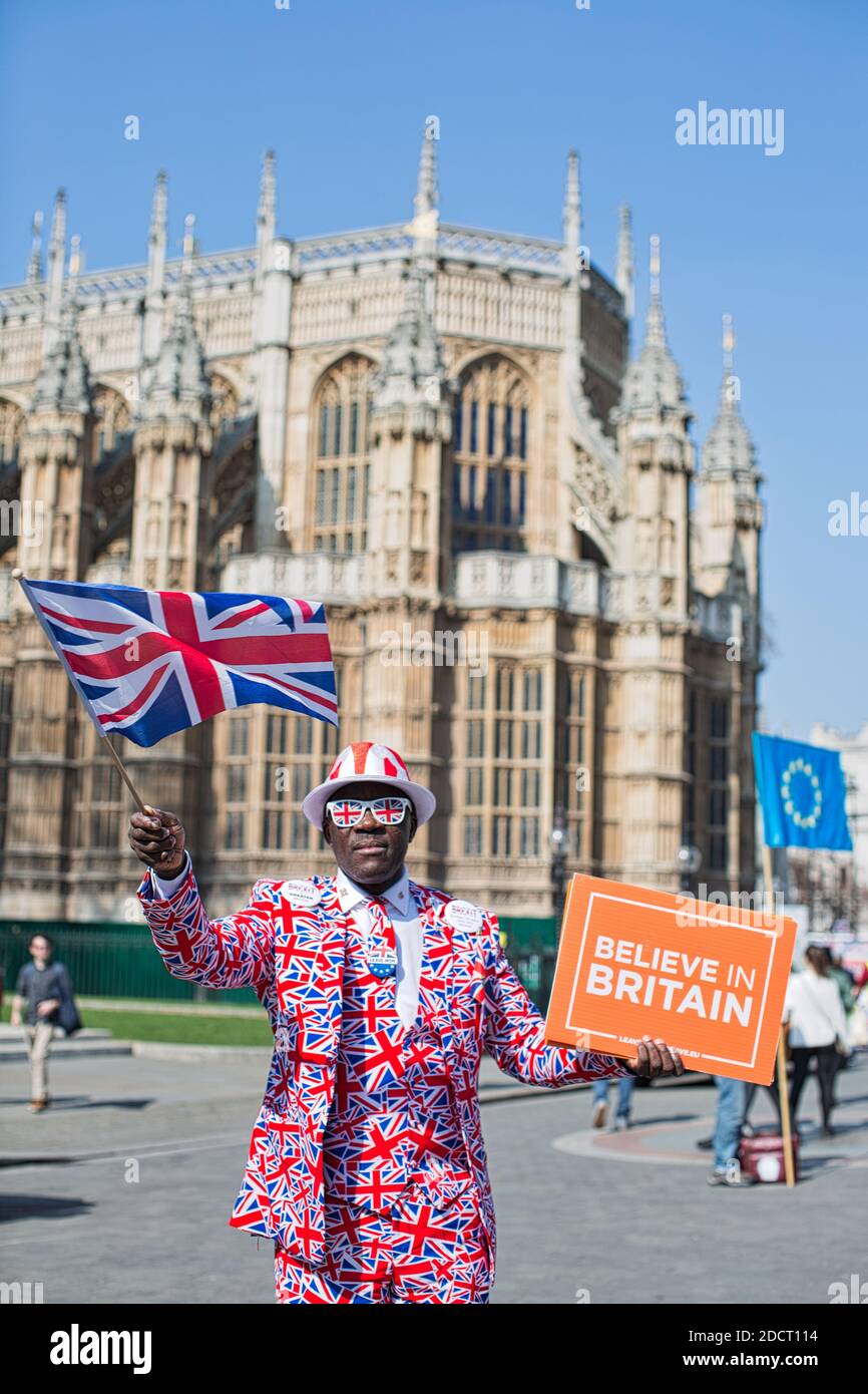 Joseph Afrane in Union Jack Suit sta protestando davanti al parlamento, tenendo il segno Believe in Britain , Londra , UK Foto Stock