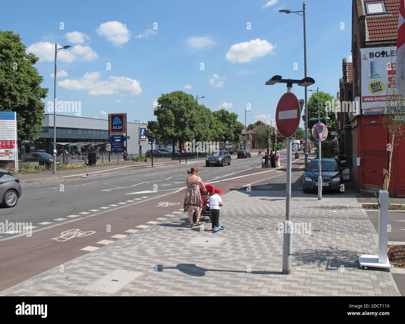 Madre e bambino attraversano un incrocio recentemente ristrutturato su Lea Bridge Road, Londra, Regno Unito. Parte del programma Mini Holland di Waltham Forest per strade più sicure Foto Stock