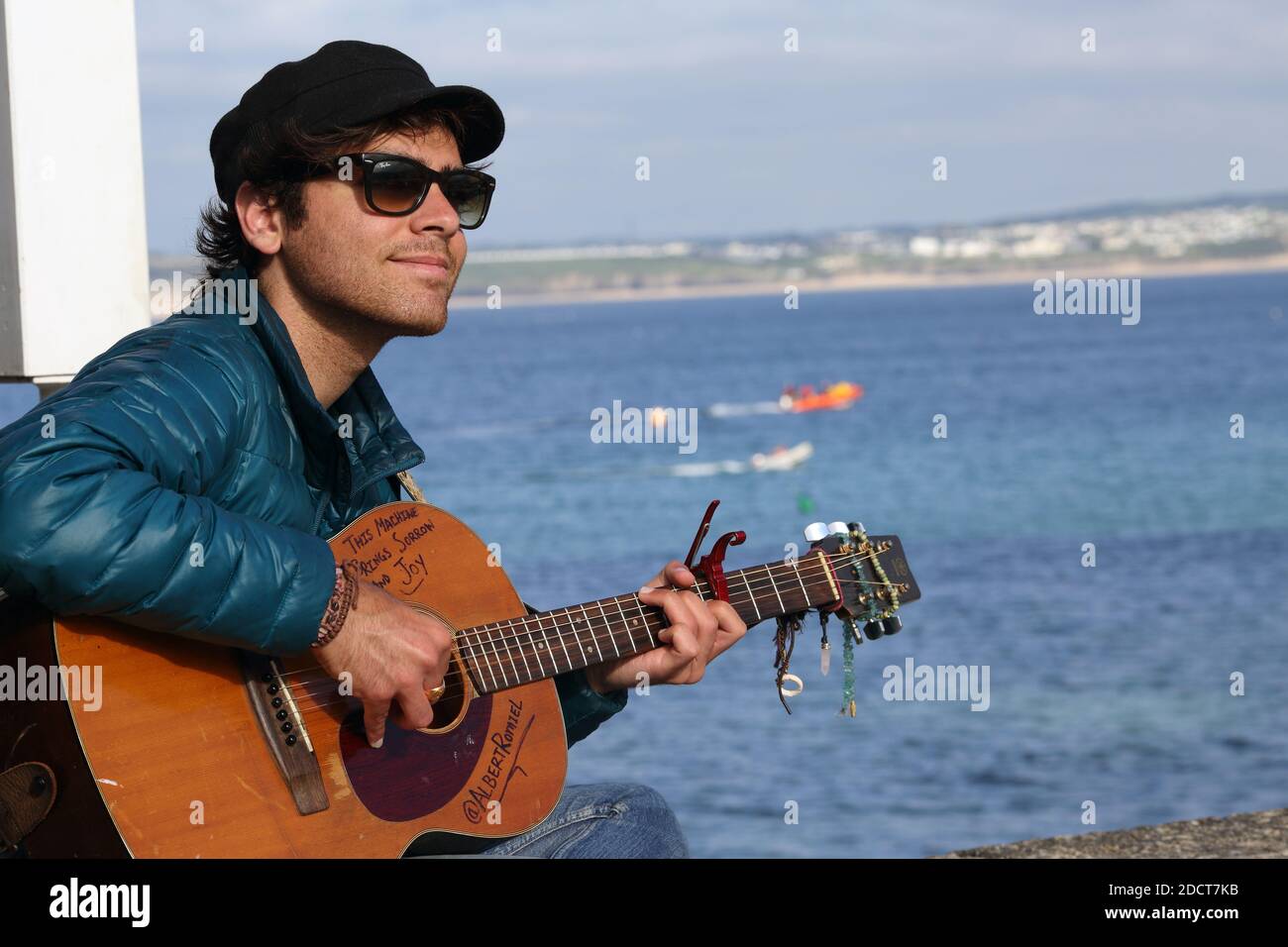 Inghilterra / Cornovaglia / St. Ives /Street Musician suona la chitarra nel porto di St Ives, Cornovaglia. Foto Stock