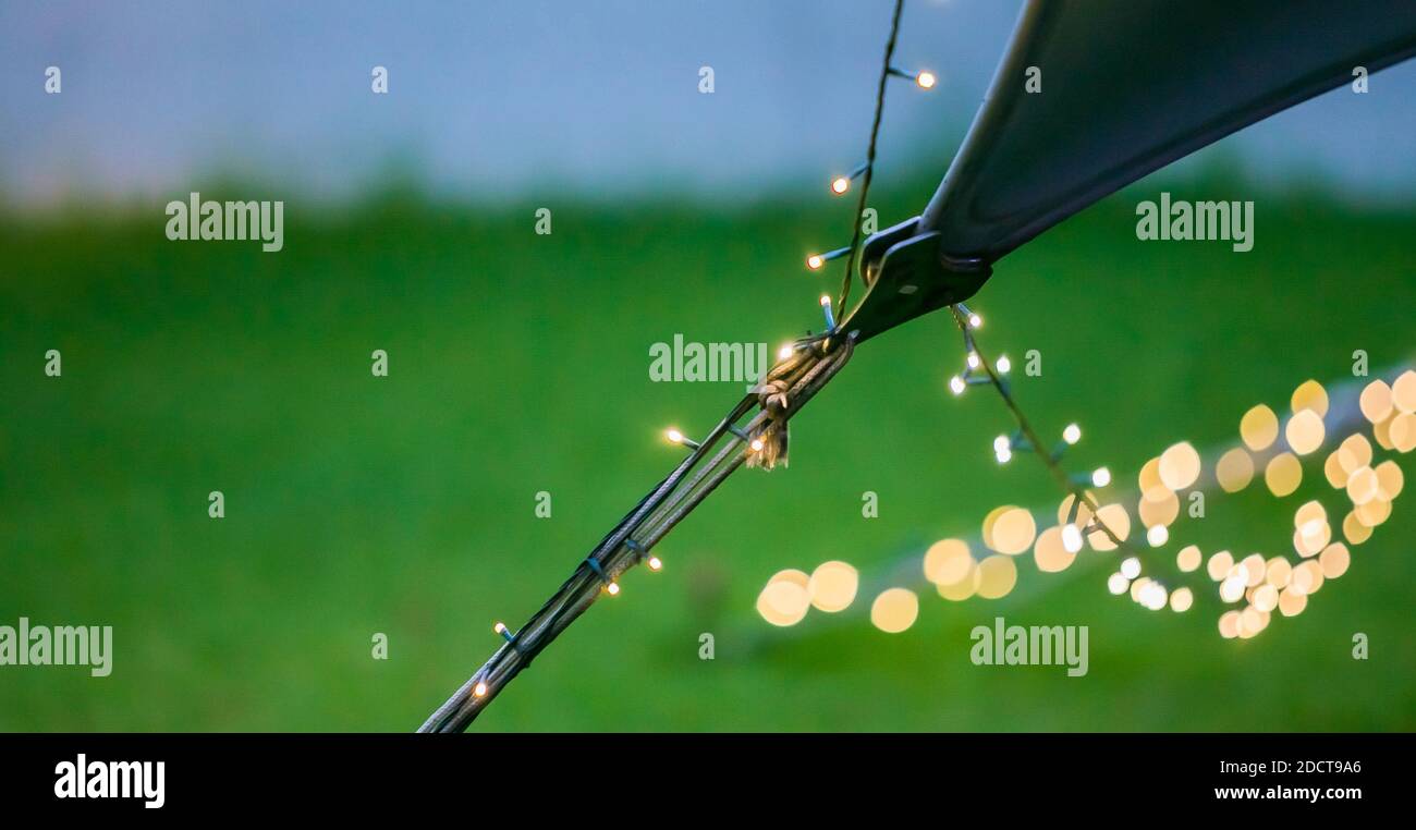 Un primo piano di bokeh fairy luci su una corda Appeso a una tenda beduina all'aperto Foto Stock