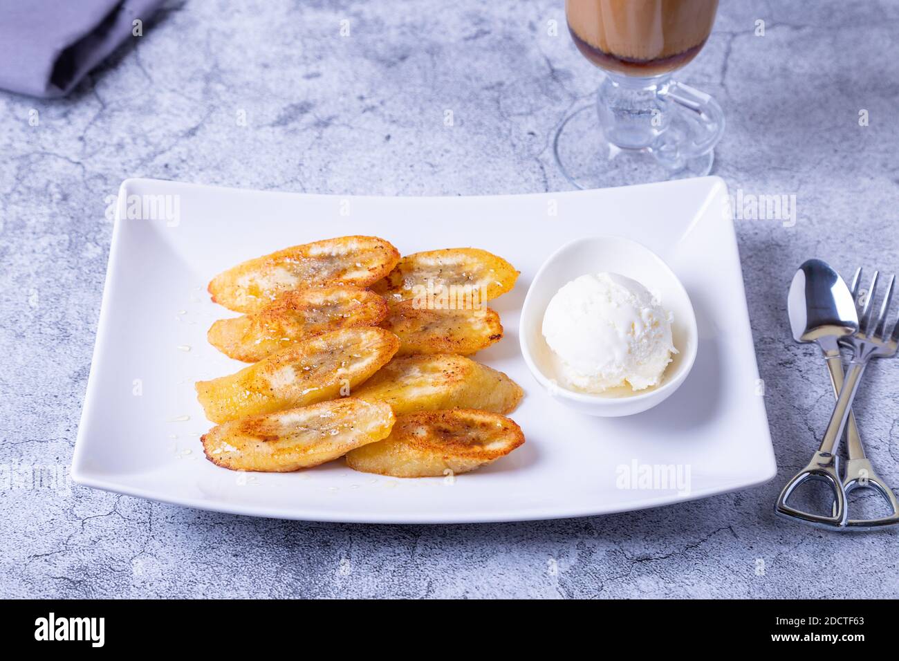 Banane fritte con miele, cannella, caffè e gelato. Primo piano. Foto Stock