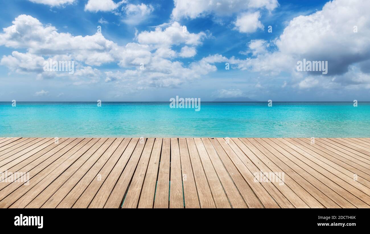 Spiaggia soleggiata con pavimento in legno e il mare turchese sull'isola Paradise. Foto Stock