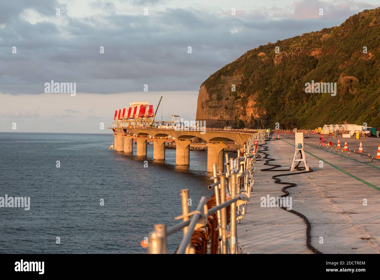 NESSUN WEB/NESSUNA APP - ESCLUSIVA. Vista generale del cantiere della Nuova autostrada costiera (Nouvelle Route du Littoral) con il lanciaponti (rosso e bianco) che depone i voussoirs (elementi a forma di cuneo) su entrambi i lati delle colonne del viadotto, nell’Isola di la Reunion, Francia nell’ottobre 2017. La nuova autostrada offshore di 12.3 km collegherà Saint-Denis, la capitale amministrativa dell’isola, con la possessione e sostituirà la strada rocciosa esistente soggetta a cadute di roccia e inondazioni durante tempeste tropicali. Avrà tre corsie in ogni direzione e migliorerà il trasporto una volta completato nel 2018. Esso Foto Stock