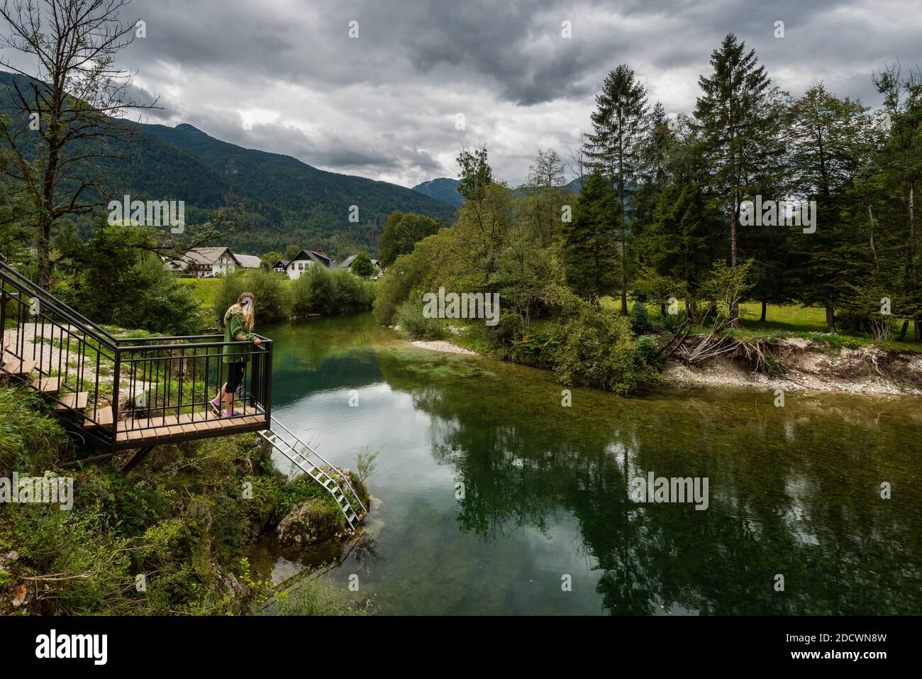 Punto panoramico in legno sul piccolo fiume con pietre rotonde bianche Sulle rive del fiume nel Parco Nazionale del Triglav in Slovenia il nuvoloso giorno d'autunno Foto Stock