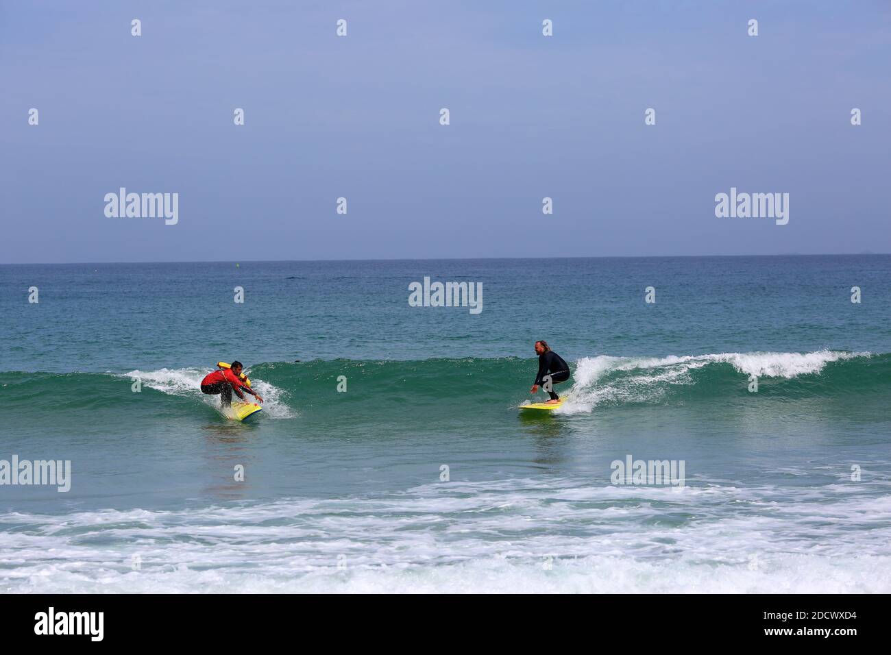 Due surfisti navigano a Great Western Beach a Newquay , Cornovaglia, Inghilterra Foto Stock