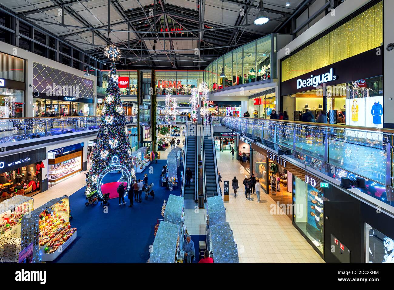 La gente cammina lungo i negozi di Donau Centrum - moderno centro commerciale decorato per le vacanze di Natale a Vienna, Foto Stock