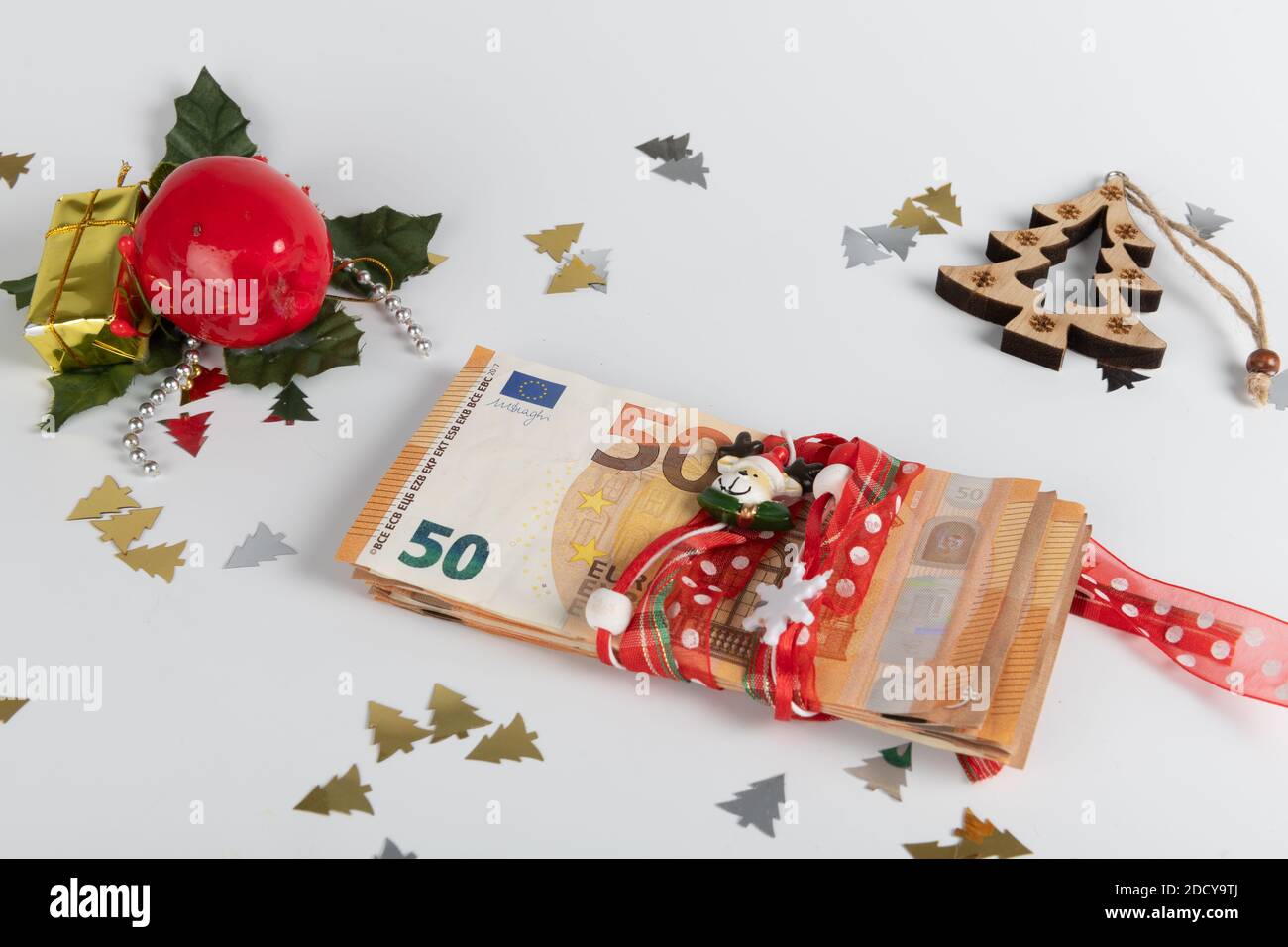 Concetto denaro e natale: Cappello di Babbo Natale e soldi in euro sfondo bianco Foto Stock
