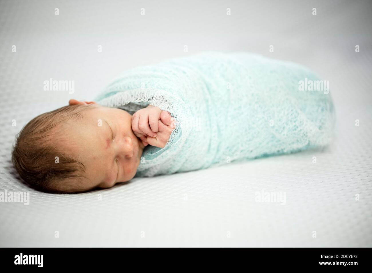Cute bambino neonato addormentato avvolto in tessuto delicato Foto Stock