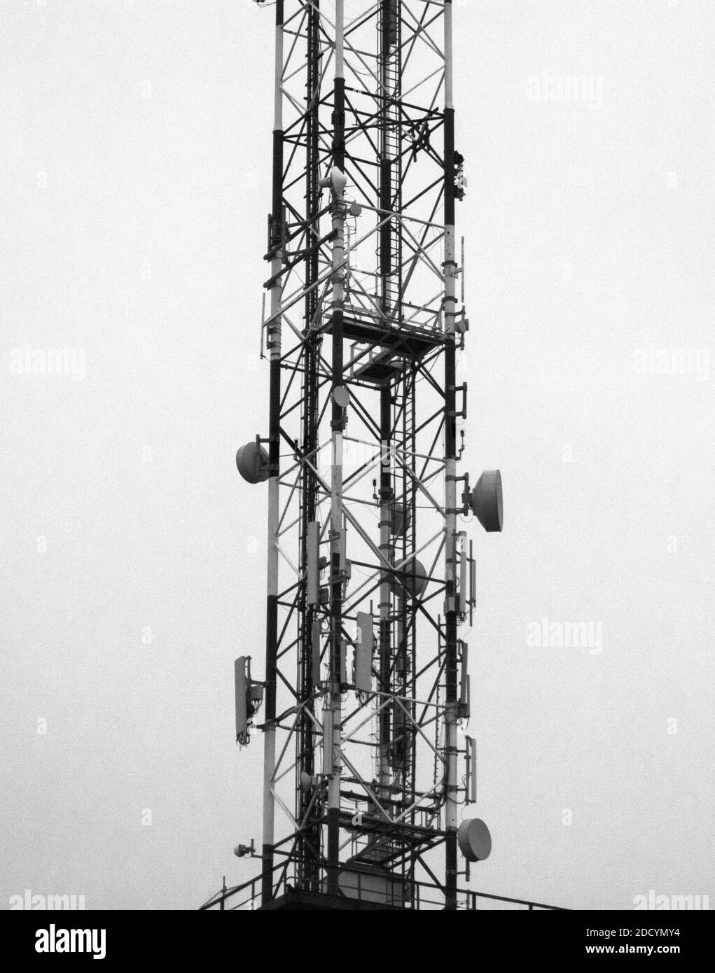 Parte di un polo di telecomunicazione al crepuscolo. Si accendono le spie notturne sul palo. Foto Stock