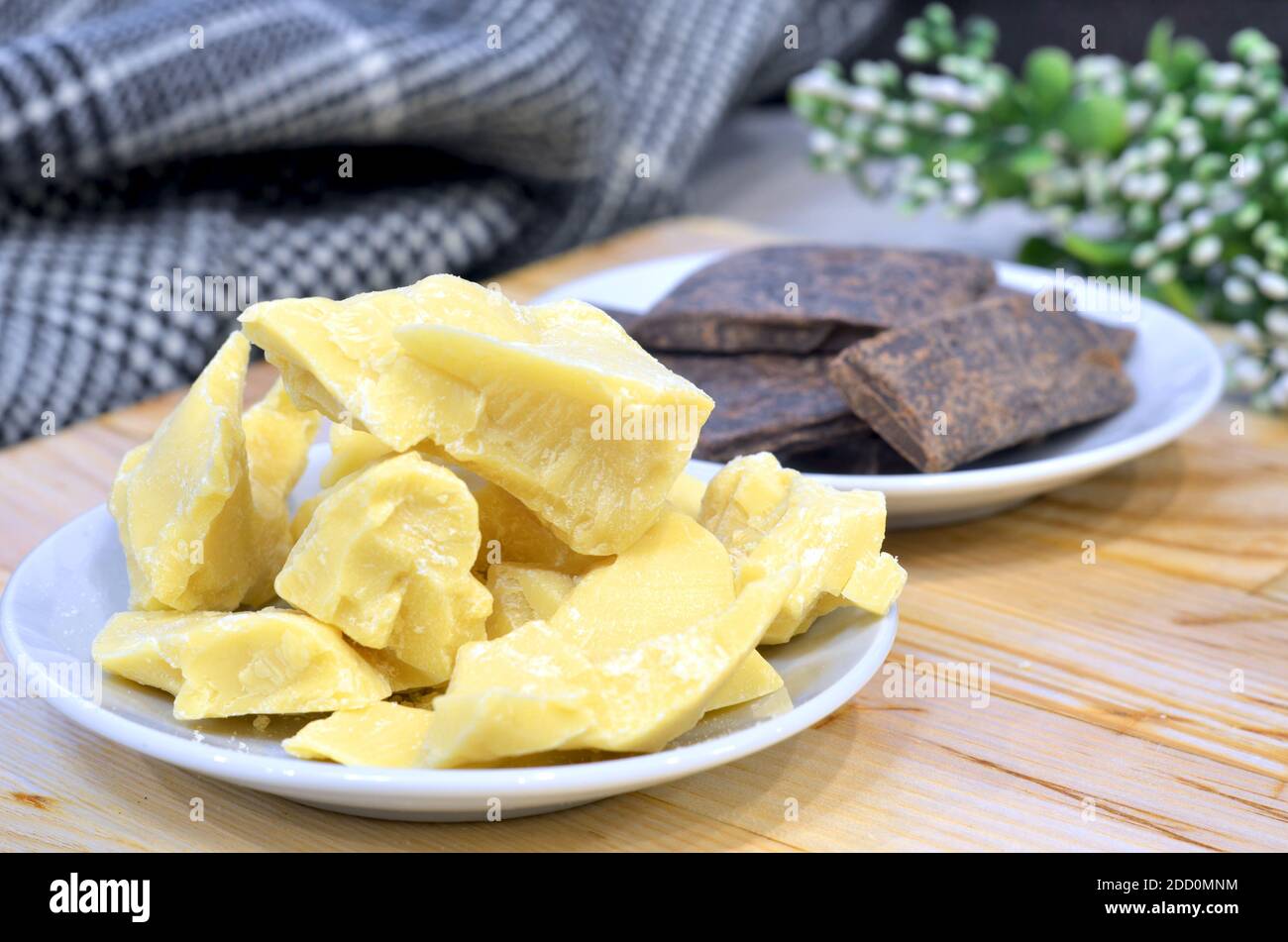 Olio di burro di cacao naturale in una ciotola di legno su un sfondo marrone Foto Stock