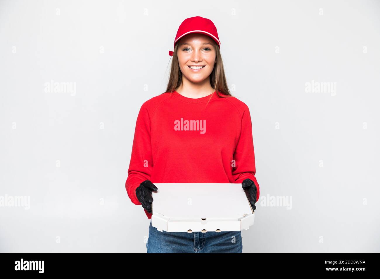 Consegna donna dipendente in rosso cappellino bianco t-shirt lavoro uniforme il corriere in attesa di servizio porta la pizza ordine del cibo in cartone scatola piatta isolata su bianco ba Foto Stock