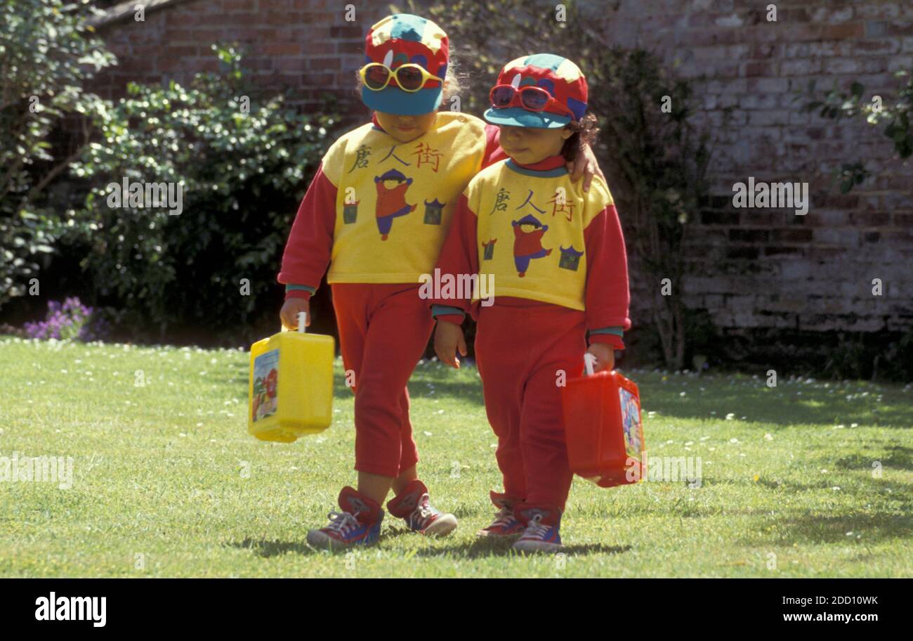 due piccole sorelle vestite allo stesso modo con box da picnic al sole giorno Foto Stock