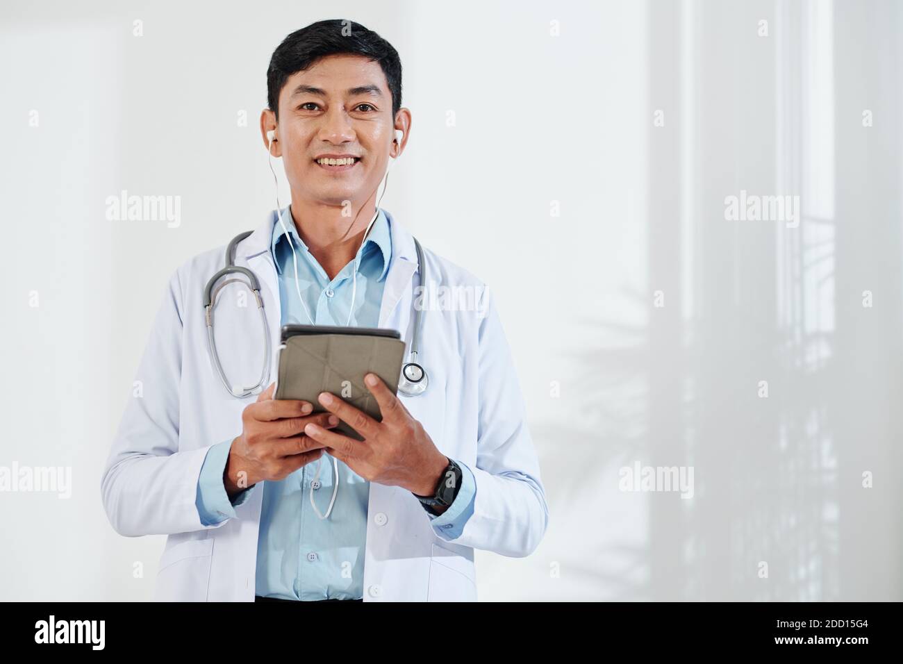 Medico di mezza età che effettua una videochiamata Foto Stock