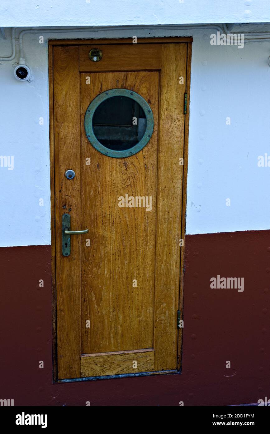 Vecchia porta in teak con oblò. Foto Stock