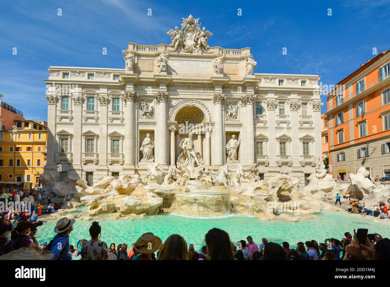 Direttamente sulla Fontana di Trevi mentre i turisti si godono la fontana barocca in una soleggiata giornata estiva in Piazza di Trevi, Roma Italia Foto Stock